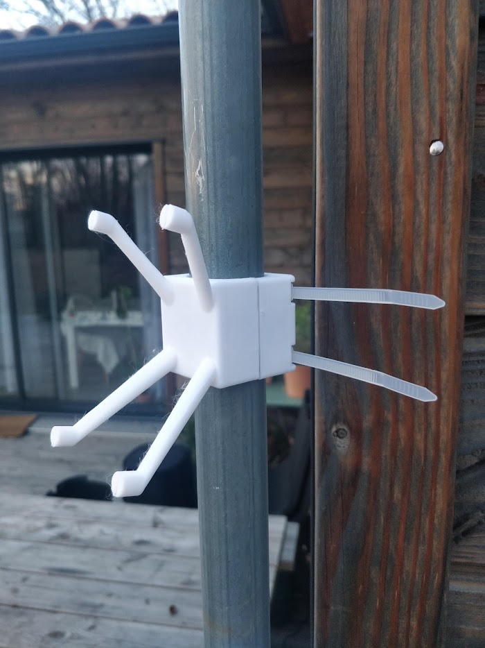 The same printed part in service, cable-tied to a pole as an anti-perch collar