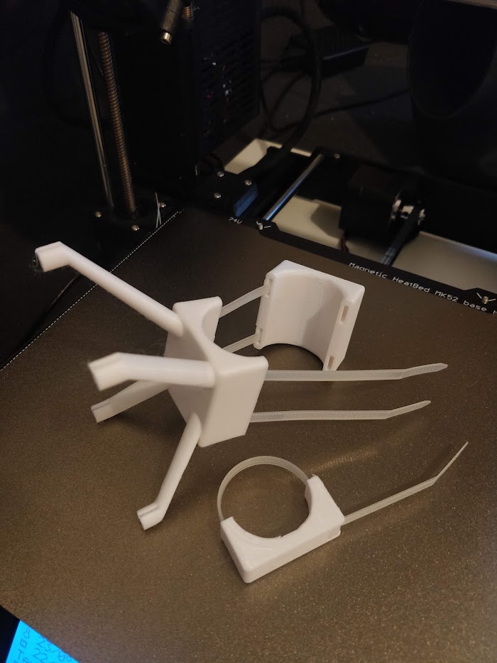 Freshly printed sensor mounts and pole clamps on the printer bed