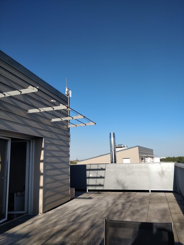 LoRaWAN gateway and antenna mounted on a rooftop terrace, sharing the skyline with other installations