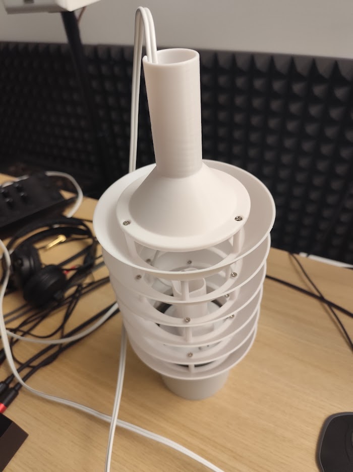 A printed particulate sensor housing with its own stack and louvred shield