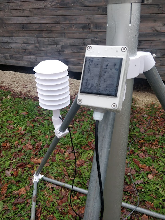 A solar-powered climate sensor in a printed radiation shield, mounted clear of the mast
