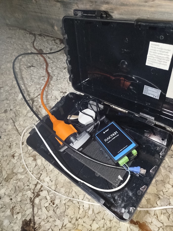A Modbus RS485 bridge installed in a weatherproof box under a building, wired into equipment that was never meant to be connected
